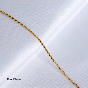 Macro shot of 18K gold-plated box chain necklace on elegant white satin background