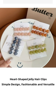 Close-up of heart and bead jelly texture duckbill hair clips in various colors on a tray