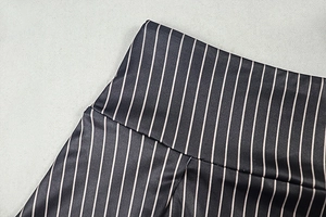 Detail of waist stitching and striped fabric texture on a women's two-piece outfit