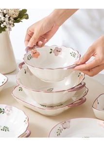 Detail of hand-painted floral ceramic bowl with pink flowers and unique purple handles