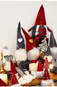 Cozy festive setting with plush Christmas gnomes, candles, and warm holiday fairy lights