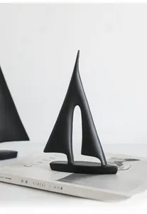 Abstrakte schwarze Segelboot-Figur mit matter Oberfläche auf minimalistischem Dekor