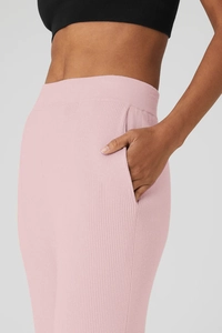 Dettaglio dei pantaloni da yoga a costine rosa con tasche laterali e vita alta