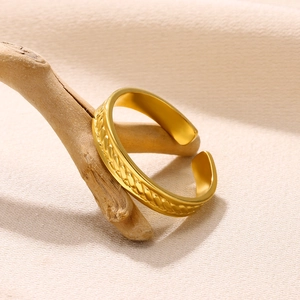 Macro shot of gold adjustable ring with twisted woven texture on a wooden branch