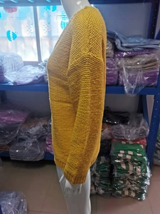 Detail of chunky knit texture and side view of bright yellow V-neck sweater on a mannequin