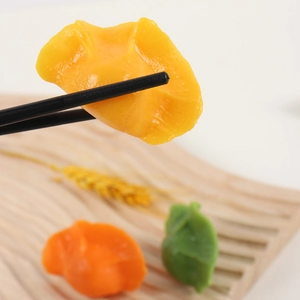 Realistic PVC dumpling models in vibrant colors being held with black chopsticks