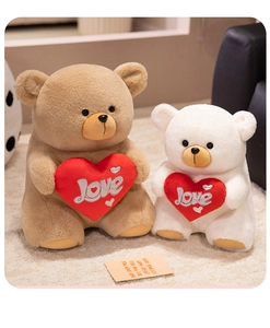 Detail of brown and white plush teddy bears holding love hearts on a soft rug