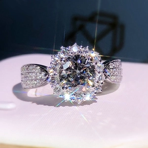 Macro d'une bague en argent avec pierre ronde et double halo de zircons sertis en pavé