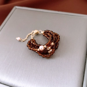 Detail of amber glass bead ring with pink pearls and adjustable gold-plated chain link