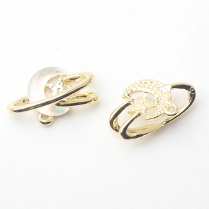 Macro shot of gold moon and planet charms for DIY jewelry making on white background