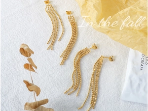 Mise à plat de boucles d'oreilles à pampilles perlées en or 18 carats sur fond jaune