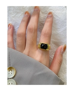 Detailed view of vintage gold textured ring with black agate stone on model finger