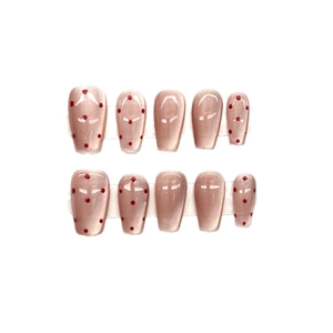 Hand-painted nude pink cat-eye press-on nails with red polka dots in long coffin shape