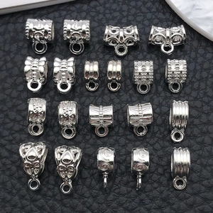 Detailed macro view of assorted silver alloy pendant bails with embossed patterns