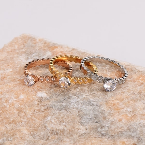 Three-color honeycomb rings in rose gold, gold, and silver finish on natural stone
