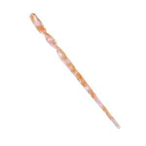 Makroansicht einer gedrehten Haarnadel mit elegantem orangefarbenem Marmormuster aus Acetat
