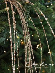 Roségouden kerstpailletten tak met kwastjes en kralen op donkergroene kerstboomtakken