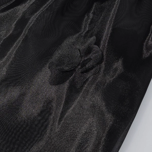 Gros plan détaillé des appliques florales 3D sur un tissu en organza noir brillant