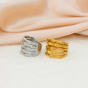 Detailed view of wide skeleton hand rings in polished silver and 18K gold finishes