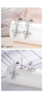 Detailed tile display of silver cross earrings with pavé cubic zirconia and spiral design
