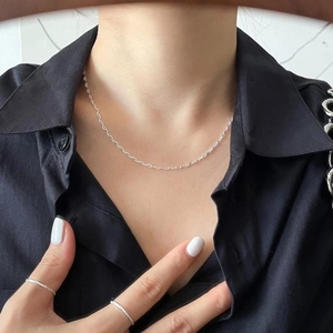 Close-up of a minimalist 925 sterling silver anchor chain necklace and matching ring set