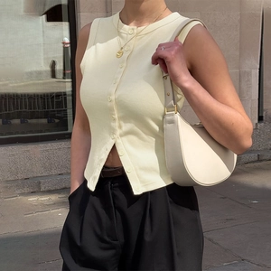 Détail d'un gilet en tricot côtelé jaune clair avec boutons porté par un mannequin