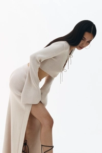 Détail d'un ensemble en tricot crème avec haut à lacets et jupe à fente haute