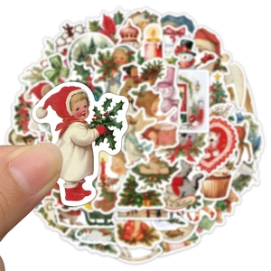 Detailed close-up of a hand holding a vintage Christmas sticker from a decorative set