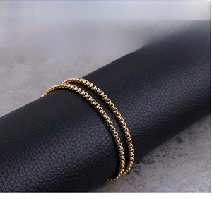 Macro shot of gold stainless steel box chain wrapped on a black display cylinder