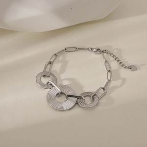 Detail view of silver metal chain bracelet with hammered rings and heart charm