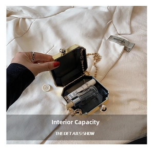 Detail view of the gold octagonal acrylic clutch bag showing internal storage capacity