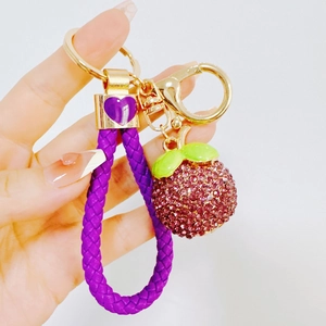 Detail of mangosteen keychain with purple woven strap and sparkling rhinestones