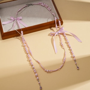 Collier multicouche en perles avec nœud en soie et pendentif cristal sur bois