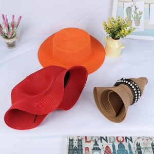 Flat lay of colorful wide brim straw sun hats with elegant pearl and lace decorations
