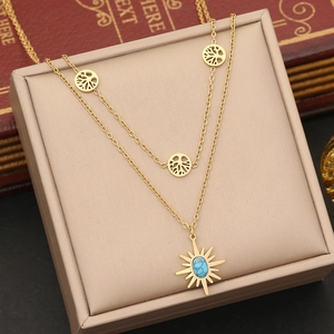 Close-up of gold double-layer necklace with Tree of Life and turquoise sun charms