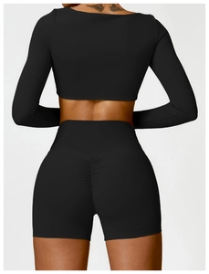 Λεπτομέρεια από μαύρο μακρυμάνικο crop top και ψηλόμεσο σορτς γυμναστικής με σούρες