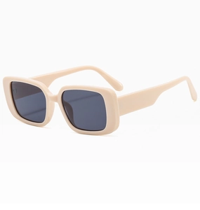 Detail view of rectangular creamy beige sunglasses with dark grey lenses at 45 degree angle