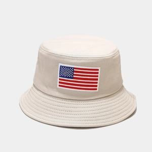 Close-up of beige cotton bucket hat with American flag embroidery and stitched brim details