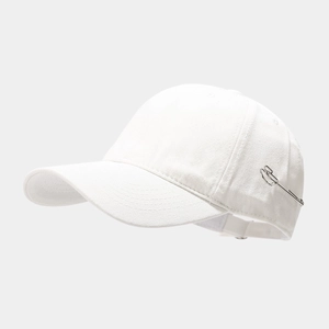Close-up of white baseball cap featuring minimalist silver metal pin detail on the side
