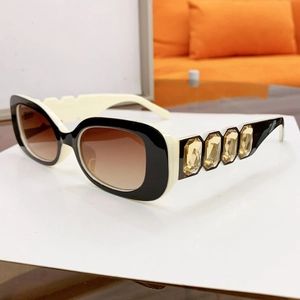 Detail of square sunglasses with amber crystal embellishments and gradient brown lenses