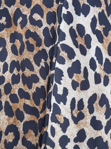 Close-up detail of leopard print fabric texture and stitching on the baseball jacket