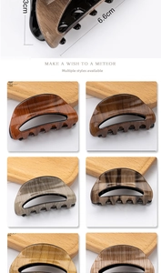 Detail view of wood-grain hair claw clips with size dimensions 6.6cm by 3cm
