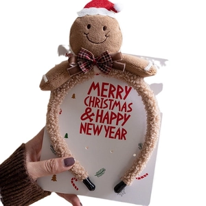 Plush gingerbread man Christmas headband with Santa hat and plaid bowtie on white background