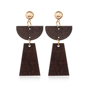 Detail view of retro geometric wood and gold metal earrings showing natural grain texture