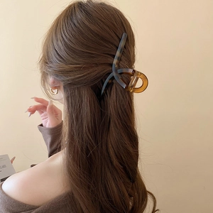Detail of leopard print hair claw clip worn on hair with elegant resin texture