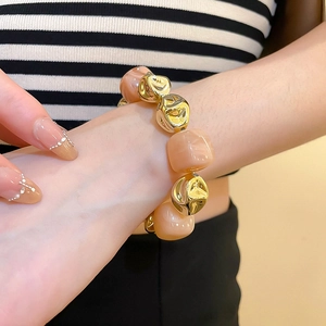 Close-up of irregular acrylic marble pink and gold beads on a stylish wrist bracelet