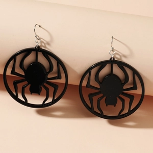Macro shot of black hollow spider earrings showing fine gothic details and silver hooks