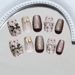 Brown cat-eye handmade press-on nails with champagne glitter and pearl bow accents