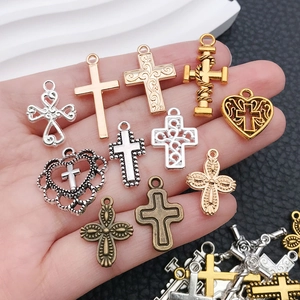 Macro-opname van 11 diverse metalen kruis- en hartbedeltjes voor het maken van sieraden