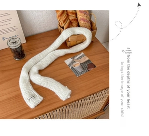 Close-up of white chunky knit scarf texture with a woven Vegetable brand label